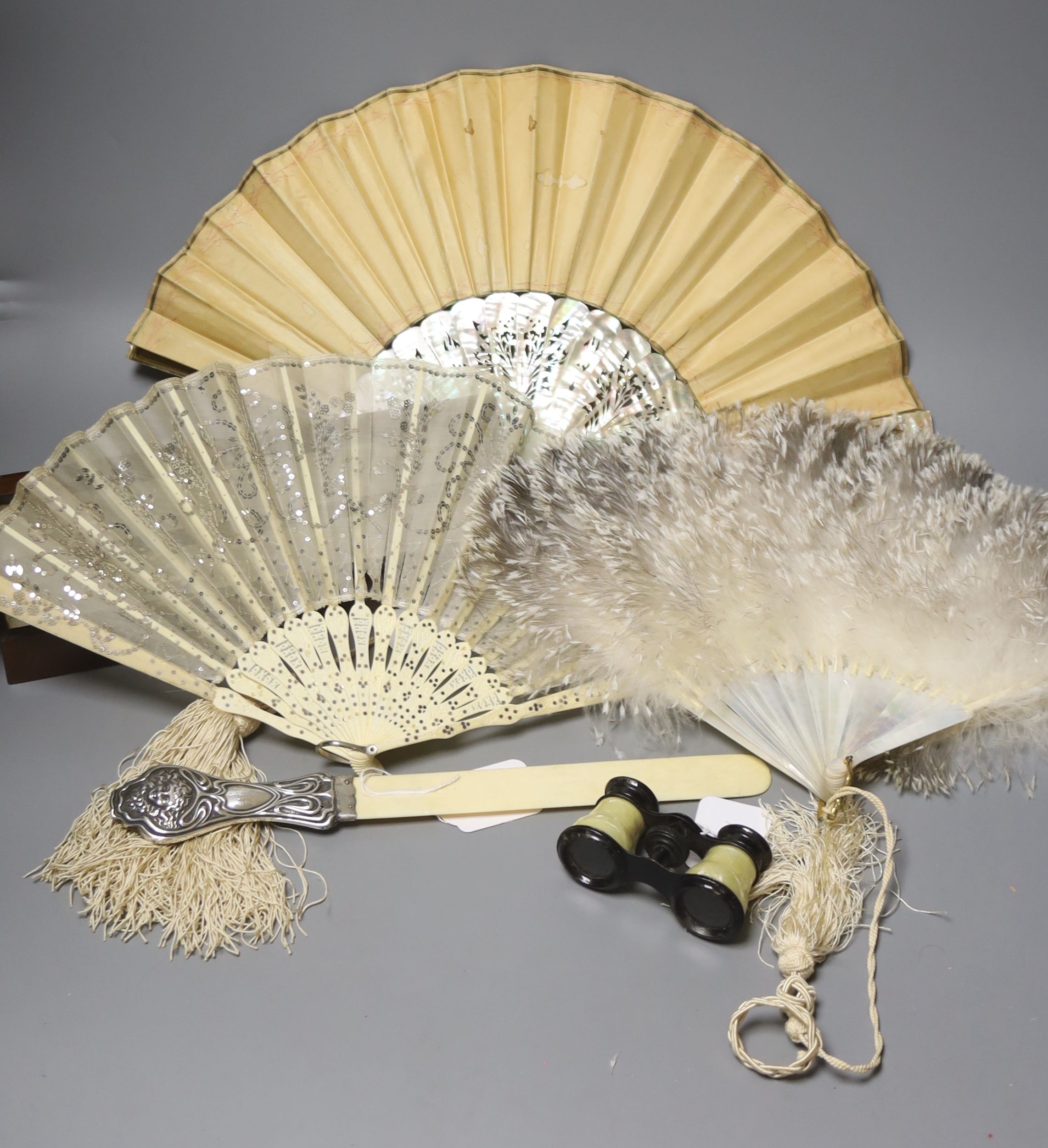 An ivory page turner with embossed white metal handle, a pair of opera glasses and three fans, various